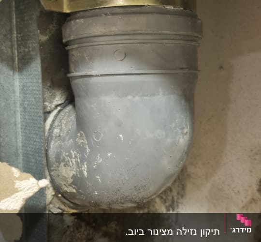 צינור פלסטיק אפור עם תושבת מתכת בקיר